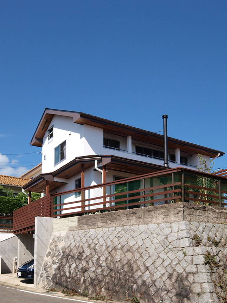 高台に建つ漆喰の家