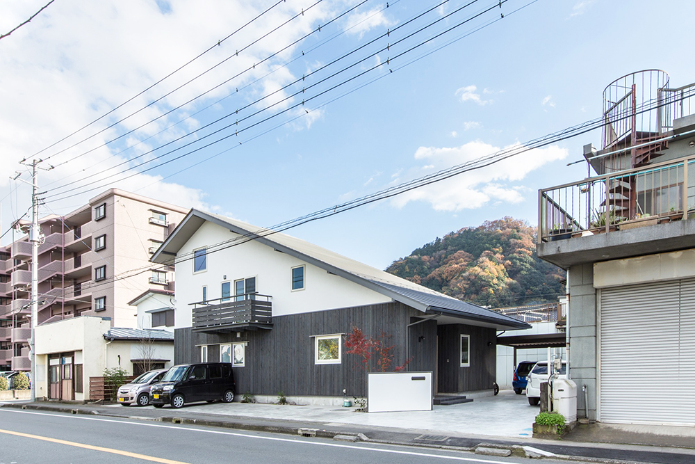 幹線道路沿いに建つ大屋根の家。