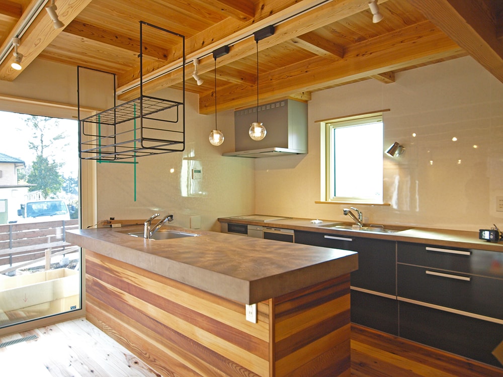 室内のキッチンは、LIXIL軒製品のキッチンと、大工が作ってモールテックスで仕上げたオリジナル天板を組み合わせ。