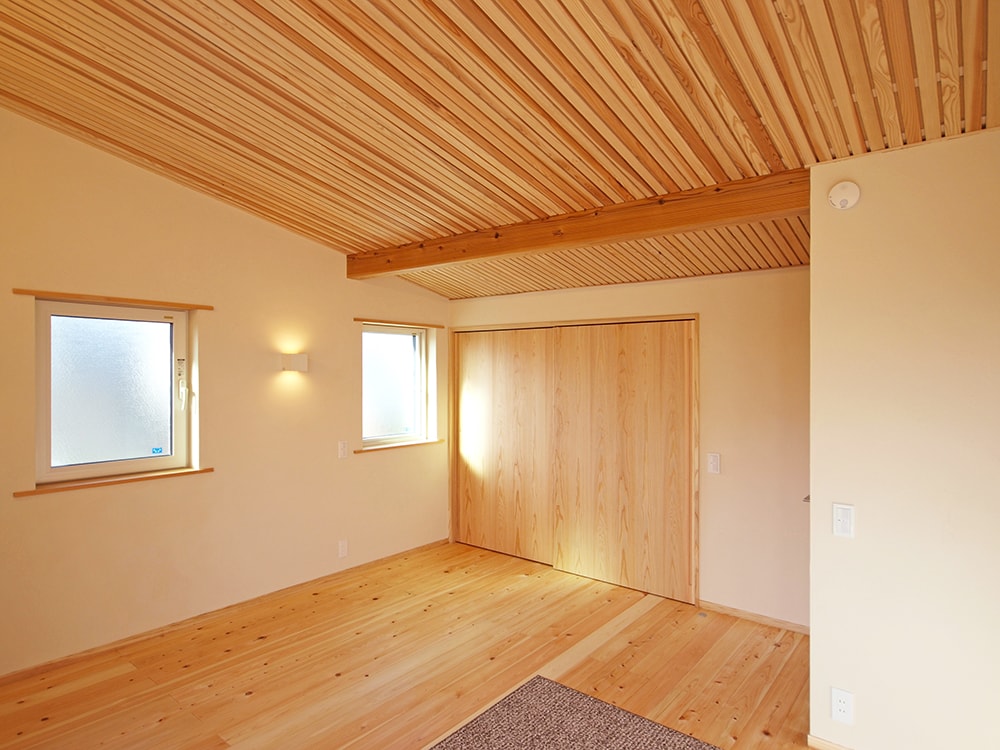 二階寝室は、壁を調湿性抜群の湯布珪藻土、天井は杉の格子仕上げとして、格子の上の木質繊維断熱材の調湿性を発揮できるようにした。