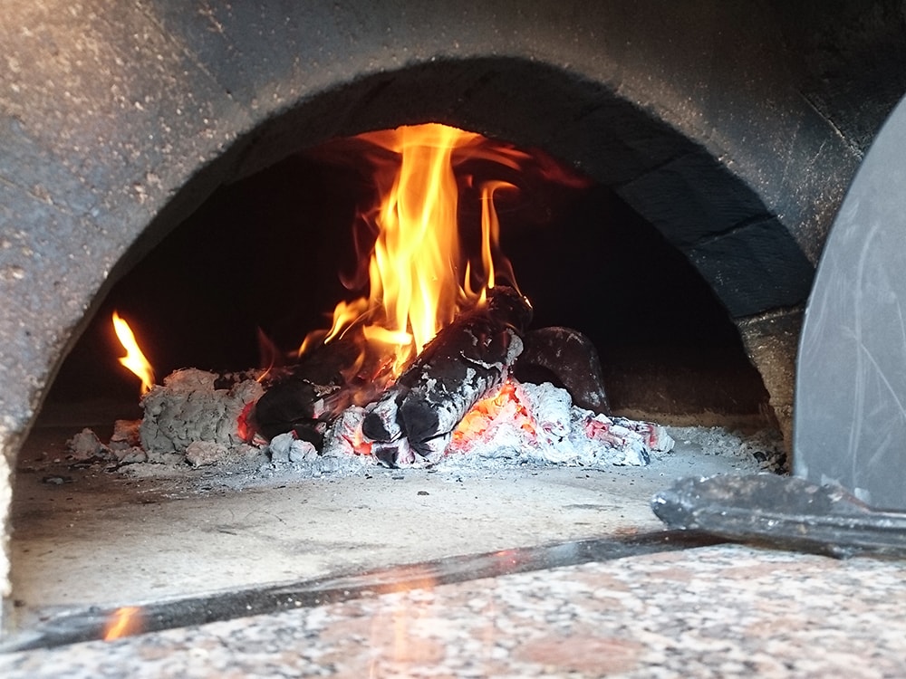 数時間とろ火で燃やし続けることで、連続して何枚もピザが焼ける。